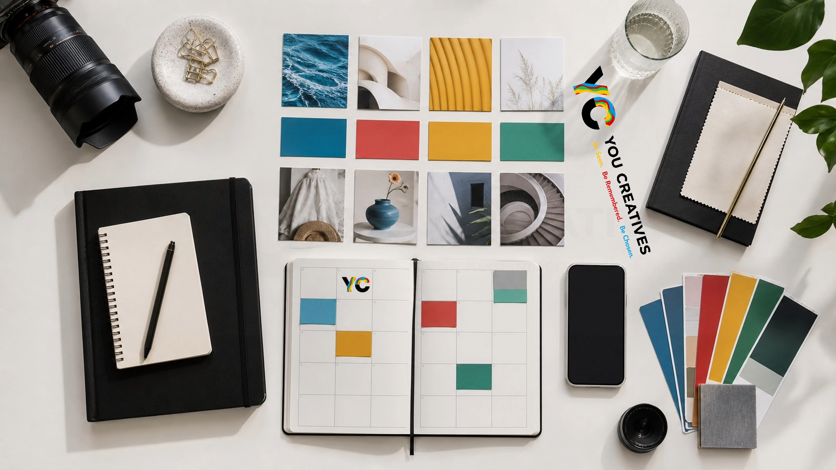 Flat lay of a camera lens, notebooks and a colour palette grid used for brand planning