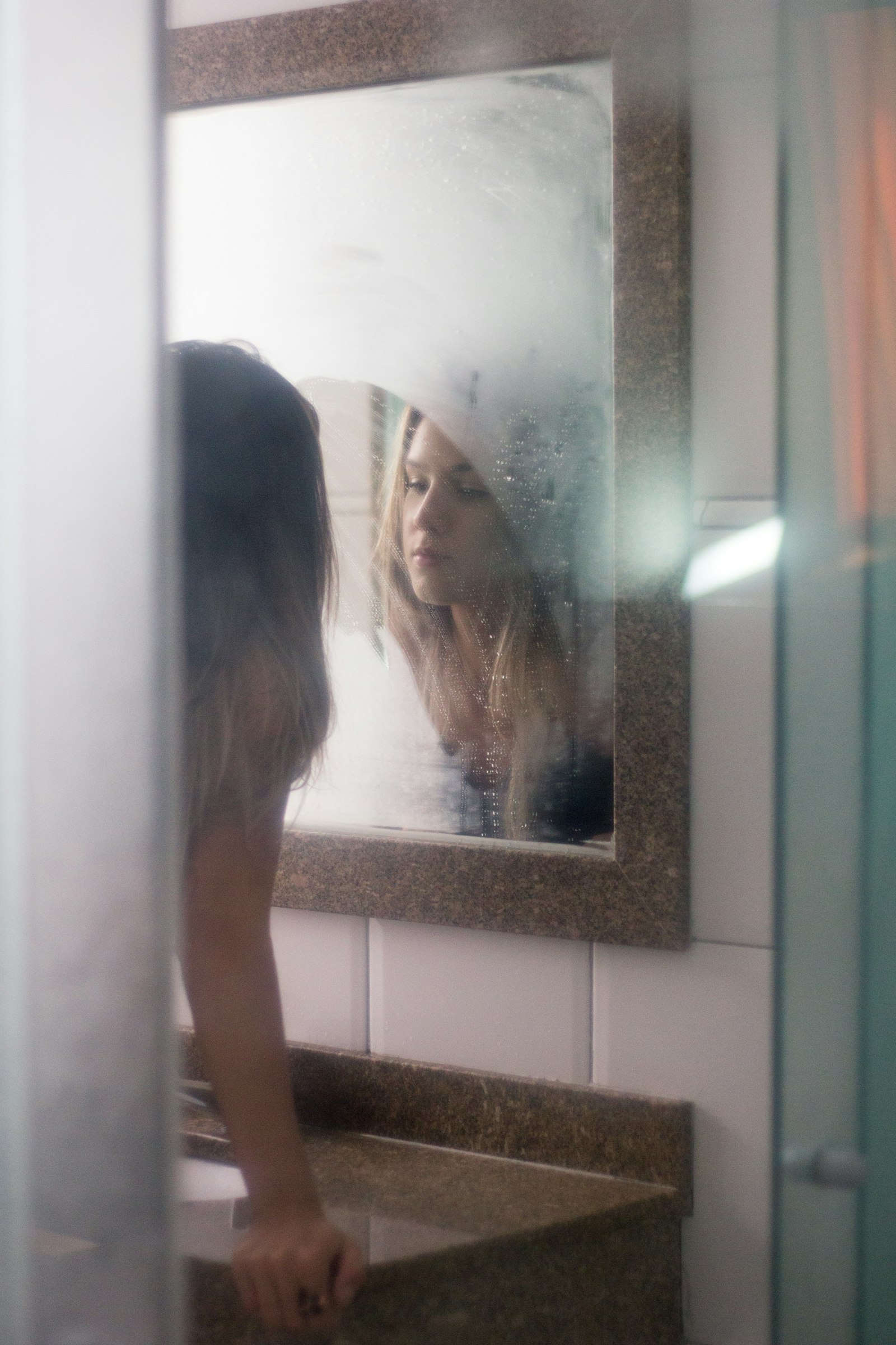 Woman reflecting on her own identity while looking in a mirror