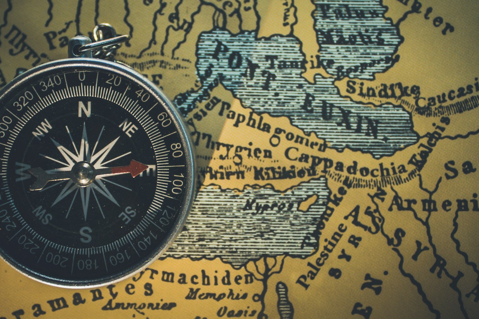 A vintage compass resting on an old hand-drawn map
